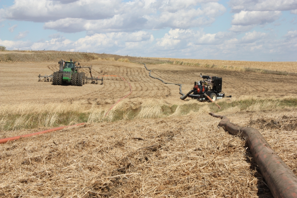 a Pump Trailer booster pump in the field in front of a hill with connected hoses