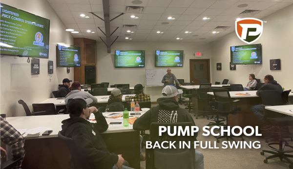 Pump School attendees in the Puck Training Center listening to the presentation with the overlaid title Pump School Back in Full Swing