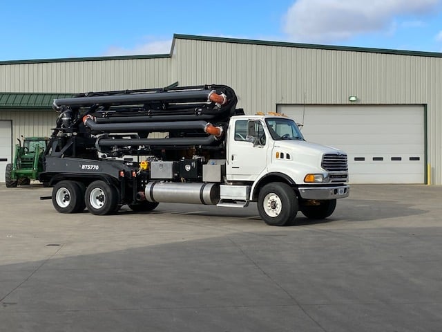 the side of a boom truck manure pump unit folded up for easy transport and storage