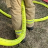 a firefighter holding a Firepower fire hose between their legs without kinking