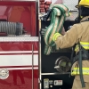 a Tripoli firefighter pulling crosslays off of a fire truck. the hose is a Hi-Combat II attack hose with a U.S. Coupling nozzle