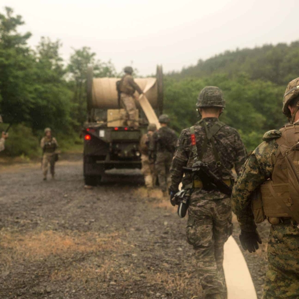 HF3CCY U.S. and Republic of Korea Marines work together to lay down a hose-reel system June 5 at Doksukri Training Area, Republic of Korea, during Korean Military Exchange Program 15-9. The hose-reel system is used to transport fuel to a fuel farm where it will be able to fuel any asset the Marine Corps has. The Marines laid 3.4 kilometers of hose, which will be used to pump 200,000 gallons of simulated fuel. KMEP 15-9 is focused on improving the engineering capabilities of each nation?s Marine Corps, all while improving relations across the region. The U.S. Marines are bulk fuel specialist with Bulk