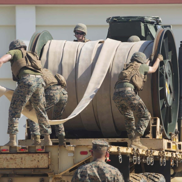 R4H8RX Marines with Bulk Fuel Company, 9th Engineer Support Battalion, 3rd Marine Logistics Group, unreel a fuel hose from the back of a Medium Tactical Vehicle Replacement 7-ton truck during fuel support operations training Oct. 2, 2018 at Camp Hansen, Okinawa, Japan. The Marines unrolled the hose to connect the fuel site and the fuel pump to distribute water, which is used during training evolutions instead of fuel, through the lines. The bulk fuel specialists assembled fuel sites at Camp Hansen in order to practice fueling support operations for upcoming exercises and deployments.