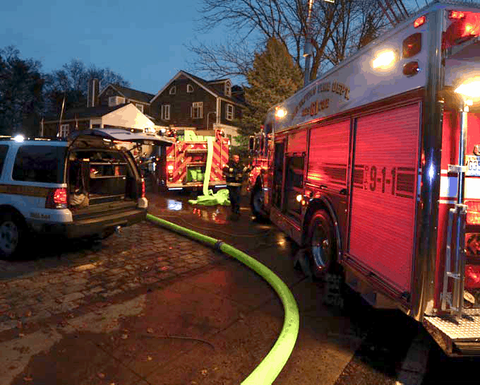 the bright yellow Hi-Vol TPU hose being used by firefighters in a residential neighborhood. the hose winds through the many trucks parked on the street