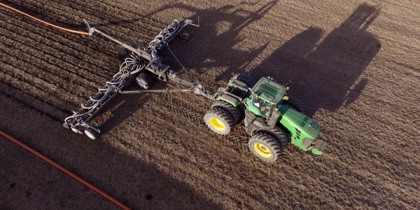 aerial view of a Puck pull-type toolbar being pulled behind a tractor with an attached hose