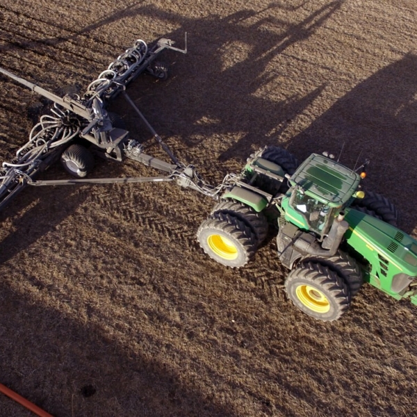 aerial view of a Puck pull-type toolbar being pulled behind a tractor with an attached hose