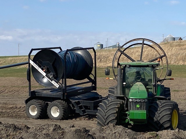 Puck Hose Mover on tractor in field