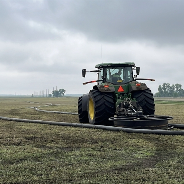tractor with hose mover shifting hose line
