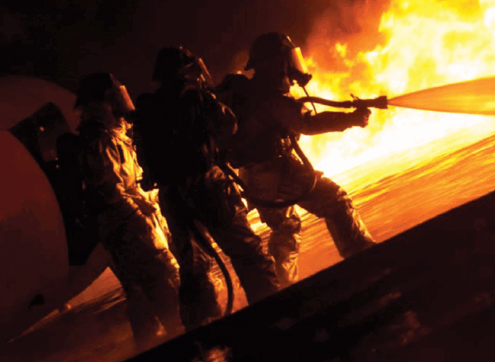 three firefighters spraying water on a fire with the Puck redskin blueskin hose