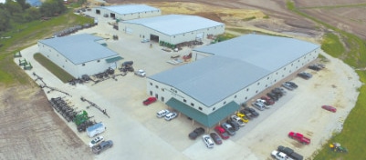 an aerial view of the Manning facility with cars and equipment parked all around the four buildings