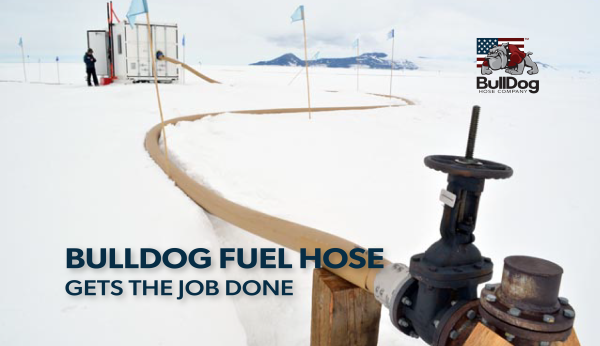 a fuel hose running from the main lone connection to a trailer in the distance with flags marking the path the hose is laying through the snow in Antarctica with the overlaid title BullDog Fuel Hose Gets the Job Done