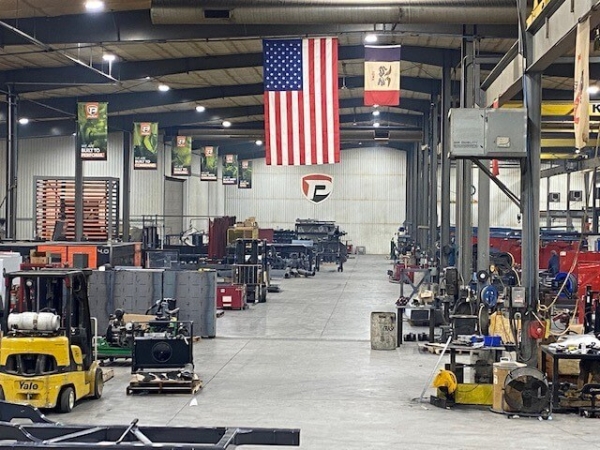 interior of Puck Enterprises warehouse with an American flag and Iowa flag hanging from the ceiling