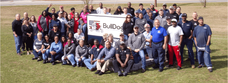 the BullDog team of employees posing together outside