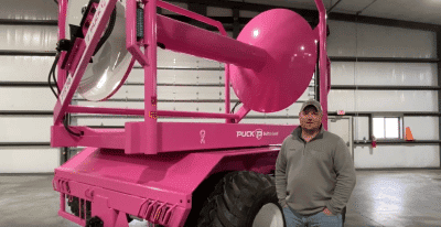 video with a man standing in front of a hose cart painted pink