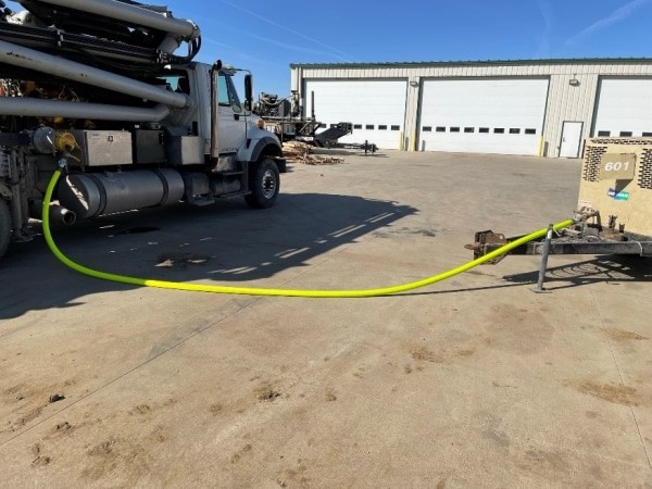 an air raid hose in use, connecting a truck to a mobile air trailer