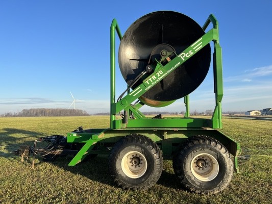 a green 2017 Puck TTR20 turn table reel hose cart parked in a field