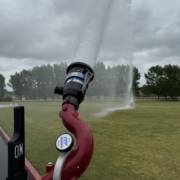 Puck Fire Foam Tote Trailer nozzle spraying water into a field