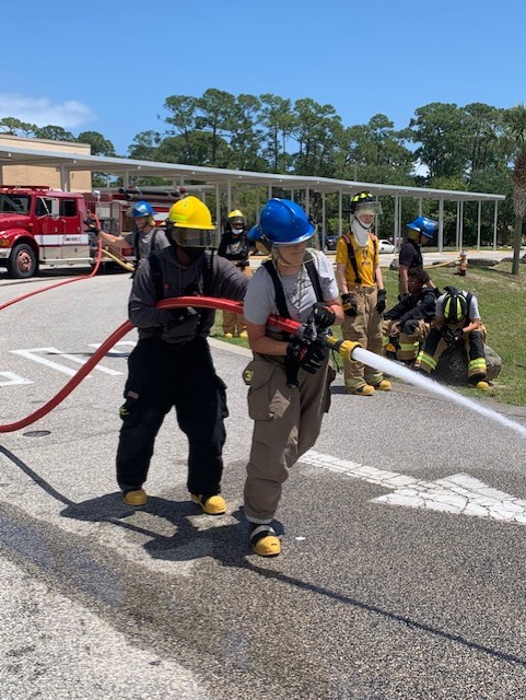 Mainland High School students in the Firefighting Program using BullDog Hose Company's Hi-Combat II red attack hose in the school parking lot