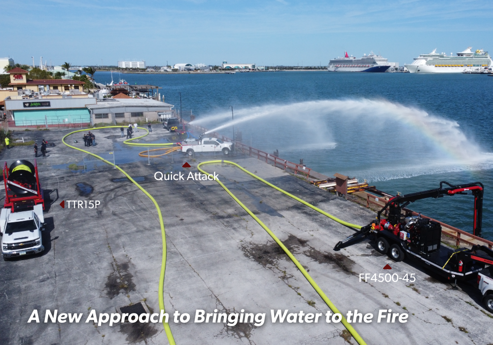 an aerial view of Port Canaveral where a FF4500-45 has a boom in the water and is connected to supply hose which was laid by the TTR15P and connects to a manifold and Quick Attack truck. The truck is spraying water across the harbor