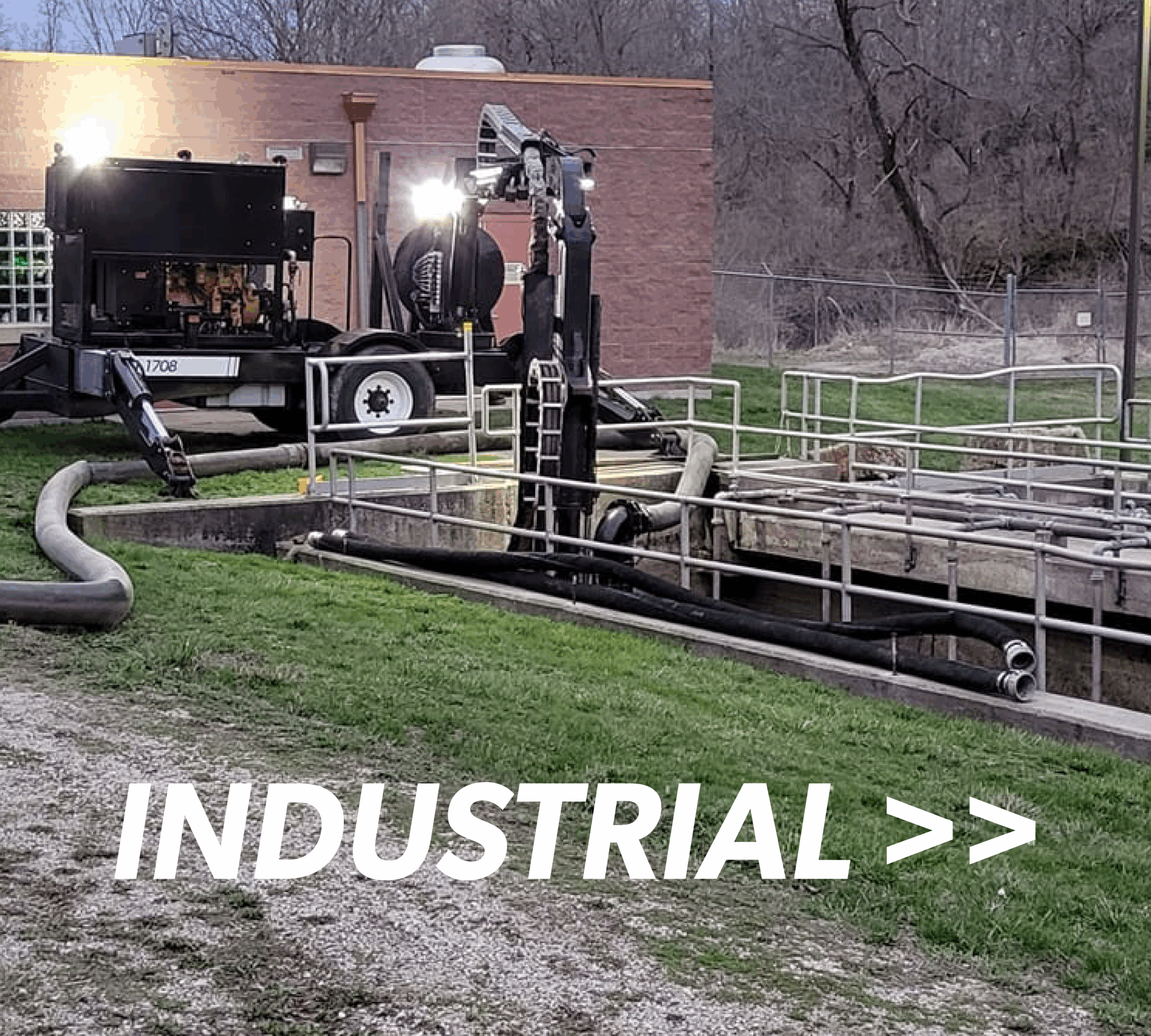 a Puck agitation trailer has a boom extended into a municipal water treatment storage facility with the overlaid title reading Industrial >>