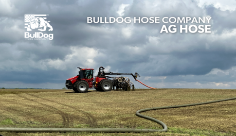 a Case IH tractor in the field with a Puck swinger and toolbar attached with mainline and drag hose connected as the applicator broadcasts manure
