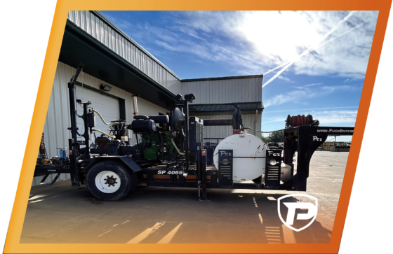 orange border around an older model Puck pump trailer sitting outside the building