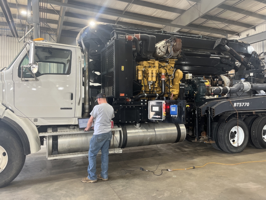 service tech connecting a boom truck to a laptop to examine lightspeed